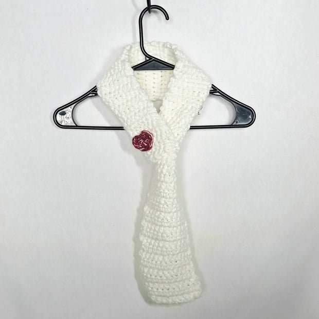 Handmade white crochet scarf with red rose accent on hanger, cozy gift by Erika Liesel