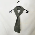 Handmade gray crochet scarf on black hanger, cozy winter accessory for gifts