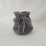 Handmade gray crochet drawstring bag, cozy and textured, perfect for small gifts or storage.