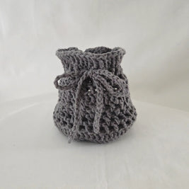 Handmade gray crochet drawstring pouch on a neutral background