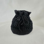 Handmade black crochet drawstring bag, cozy and textured for everyday use or gifting.
