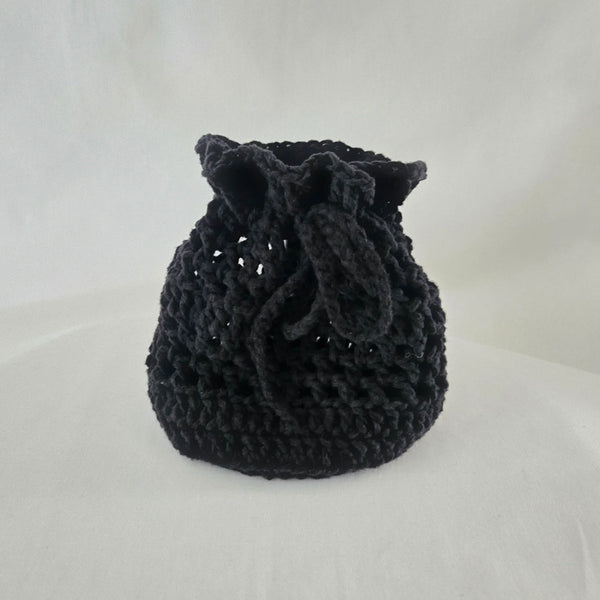 Handmade black crochet drawstring bag, cozy and textured for everyday use or gifting.