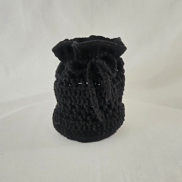 Handmade black crochet drawstring pouch on white background, cozy gift by Erika Liesel