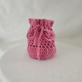 Handmade pink crochet drawstring bag by Erika Liesel on a white background