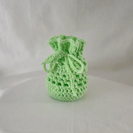 Handmade light green crochet gift bag on a white background, cozy and creative design