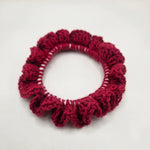 Handmade red crochet hair scrunchie with ruffled texture, cozy and creative accessory