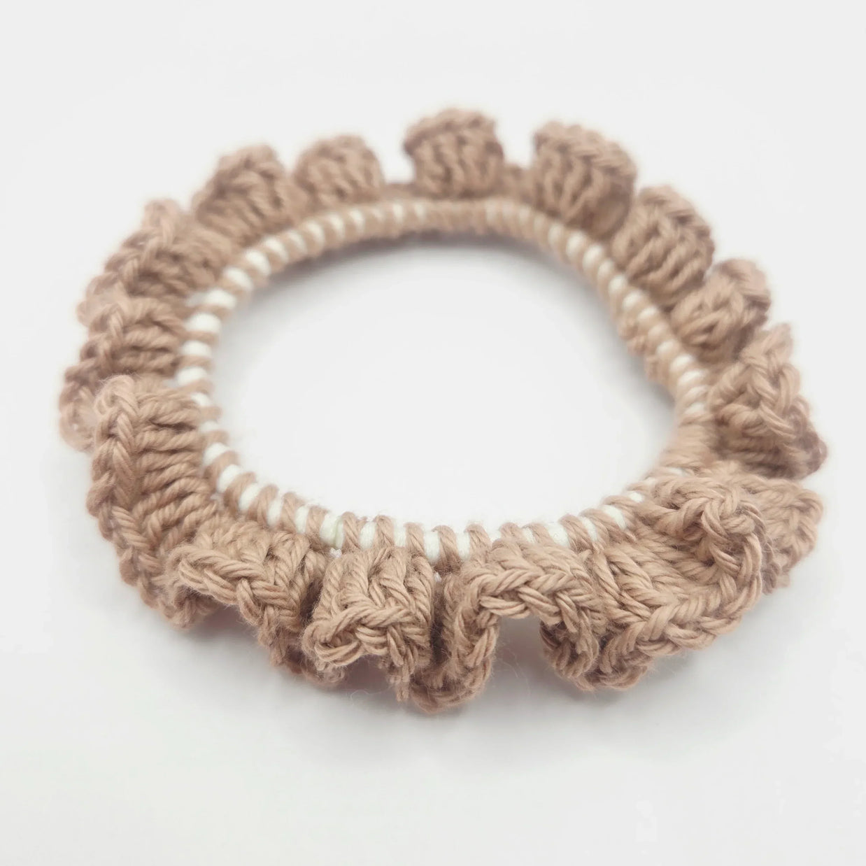 Handmade beige crochet scrunchie on white background, cozy accessory by Erika Liesel