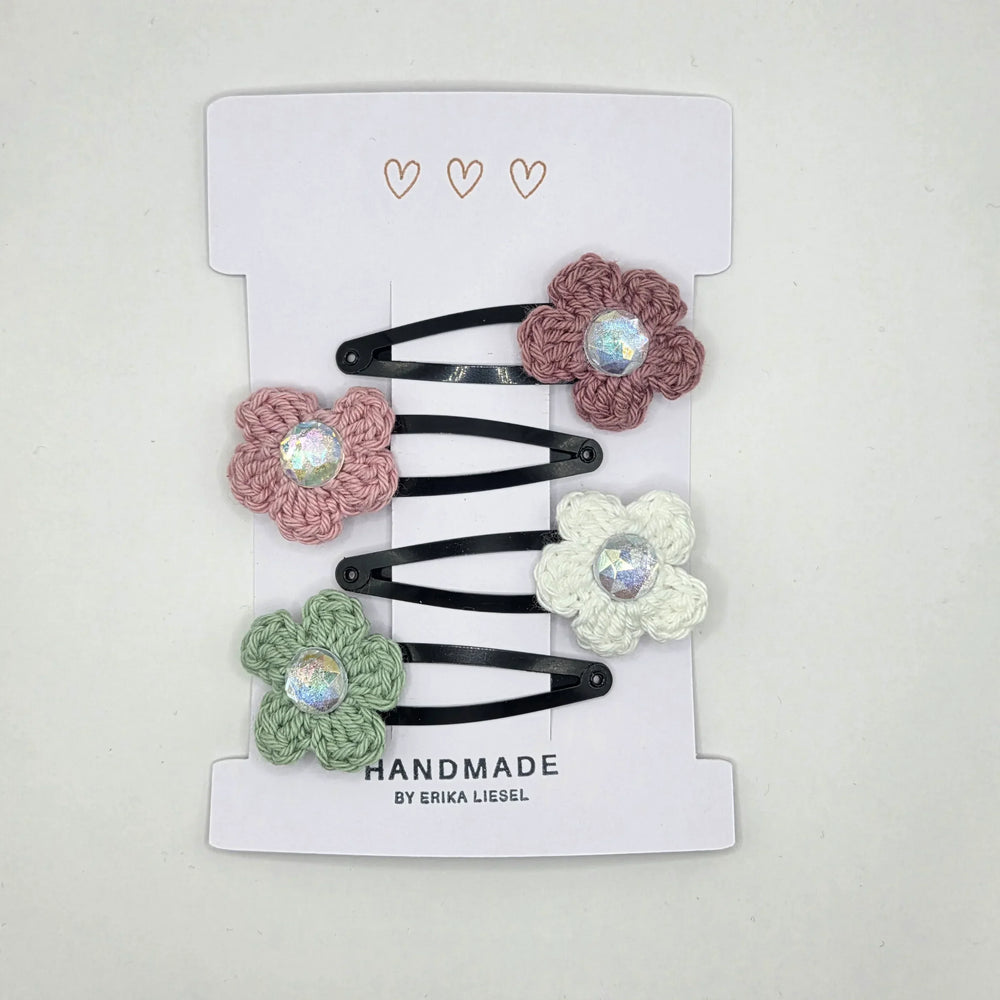 Handmade crochet flower hair clips with iridescent gems, soft pastel colors, perfect for cozy, creative styling.