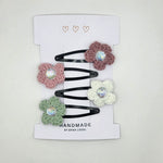 Handmade crochet flower hair clips with iridescent gems, soft pastel colors, perfect for cozy, creative styling.