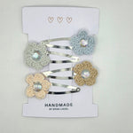 Handmade crochet flower hair clips with rhinestone centers, soft pastel colors, perfect for cozy gifts