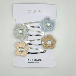Handmade crochet flower hair clips by Erika Liesel on white card display