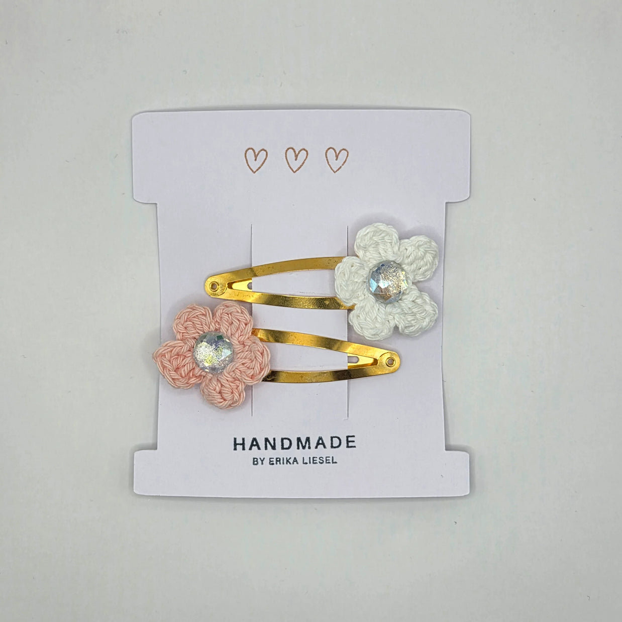 Handmade crochet flower hair clips with gems on a card labeled Erika Liesel