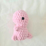 Pink crocheted octopus toy with black button eye, handmade cozy gift for babies