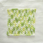 Handmade crochet dishcloth in green and white, cozy kitchen textile for everyday use