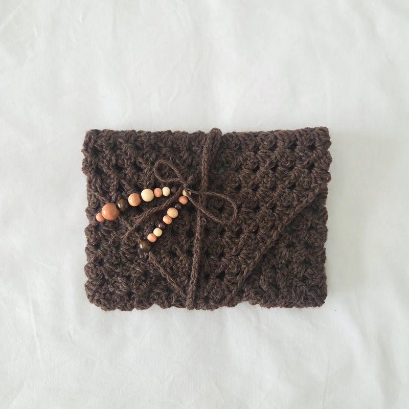 Handmade brown crochet clutch with wooden beads and drawstring closure, cozy artisan gift