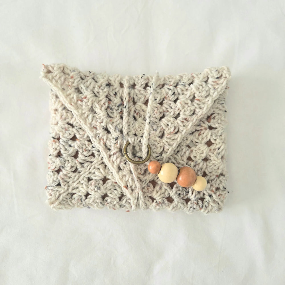 Handmade crochet clutch with wooden beads and metal ring, cozy boho accessory