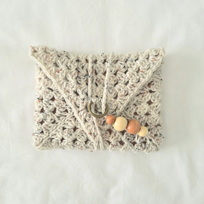 Handmade crochet clutch with wooden beads and metal ring, cozy boho accessory