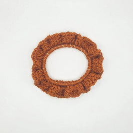 Handmade brown crochet scrunchie on white background, cozy hair accessory by Erika Liesel