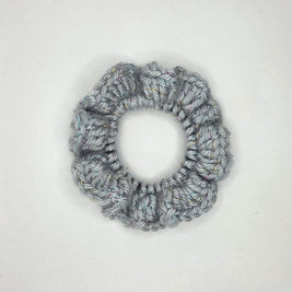 Handmade silver crochet scrunchie with subtle sparkles on a white background
