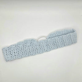 Light blue knitted headband on a white background