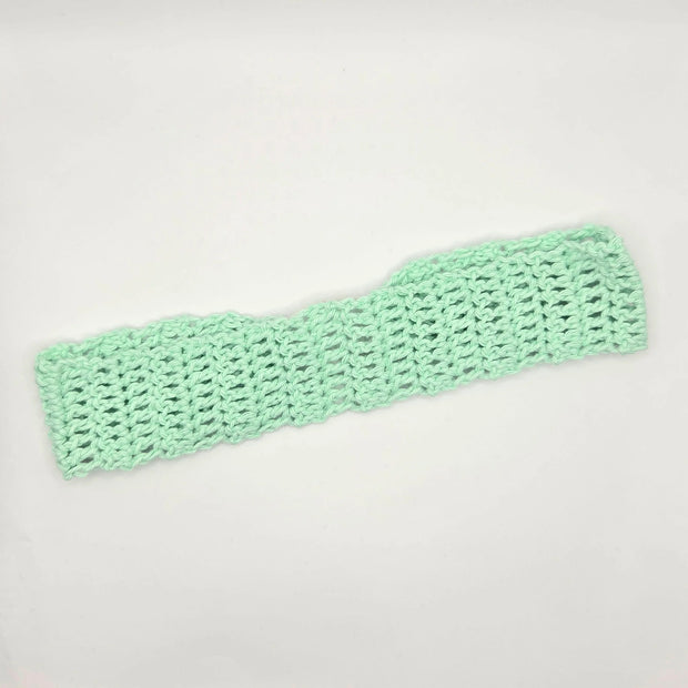 Handmade mint green crochet headband on white background, cozy crochet accessory gift