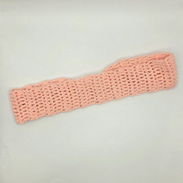 Handmade light pink crochet headband on plain background, cozy gift by Erika Liesel