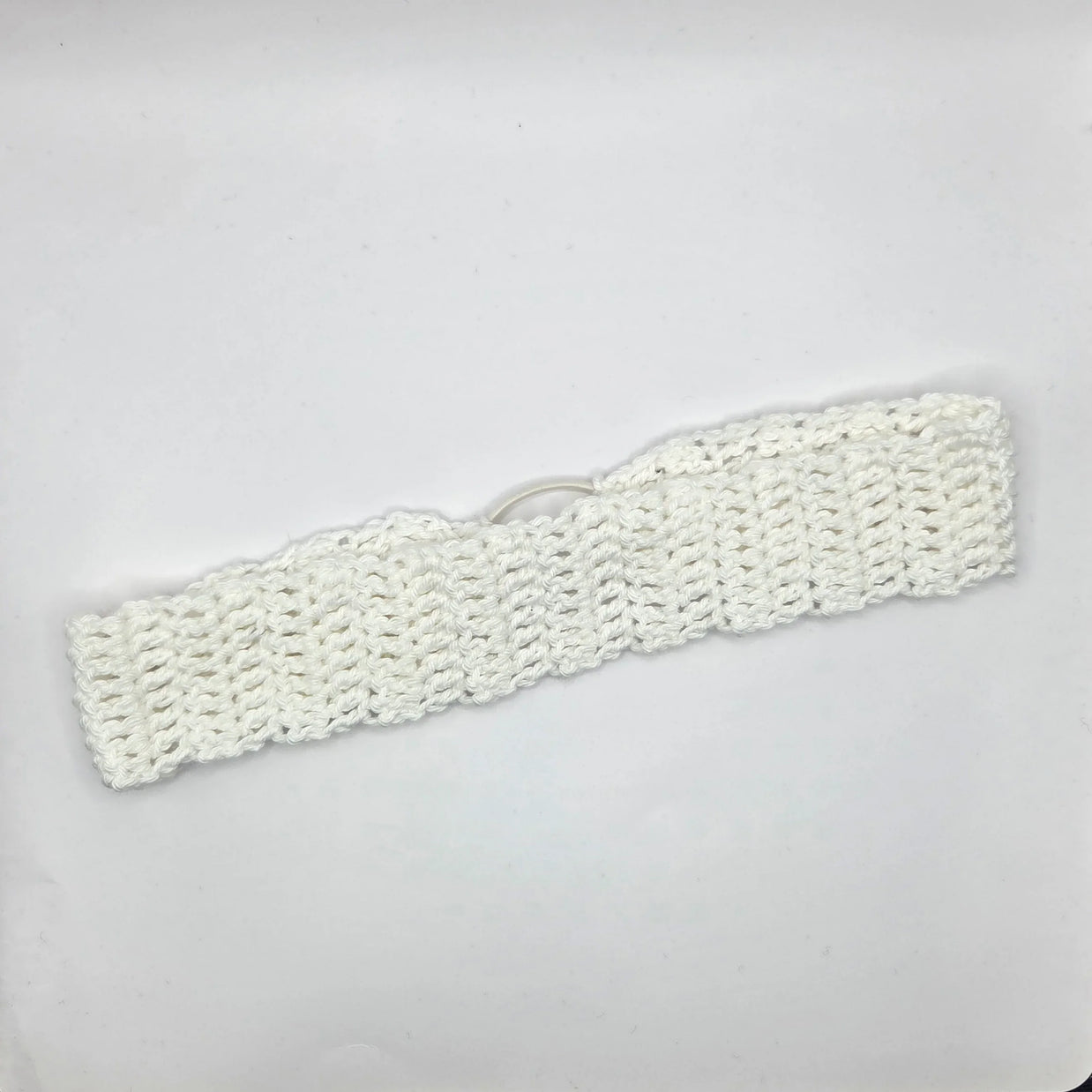 Handmade white crochet headband on plain background, cozy crochet gift by Erika Liesel