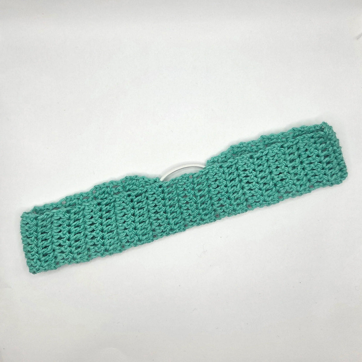 Green knitted headband on a white background