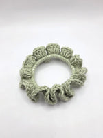 Handmade crochet hair scrunchie in soft sage green, cozy and textured for everyday wear.