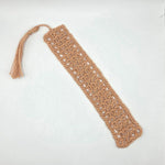 Handmade crochet bookmark with tassel, cozy and creative reading accessory in soft peach yarn