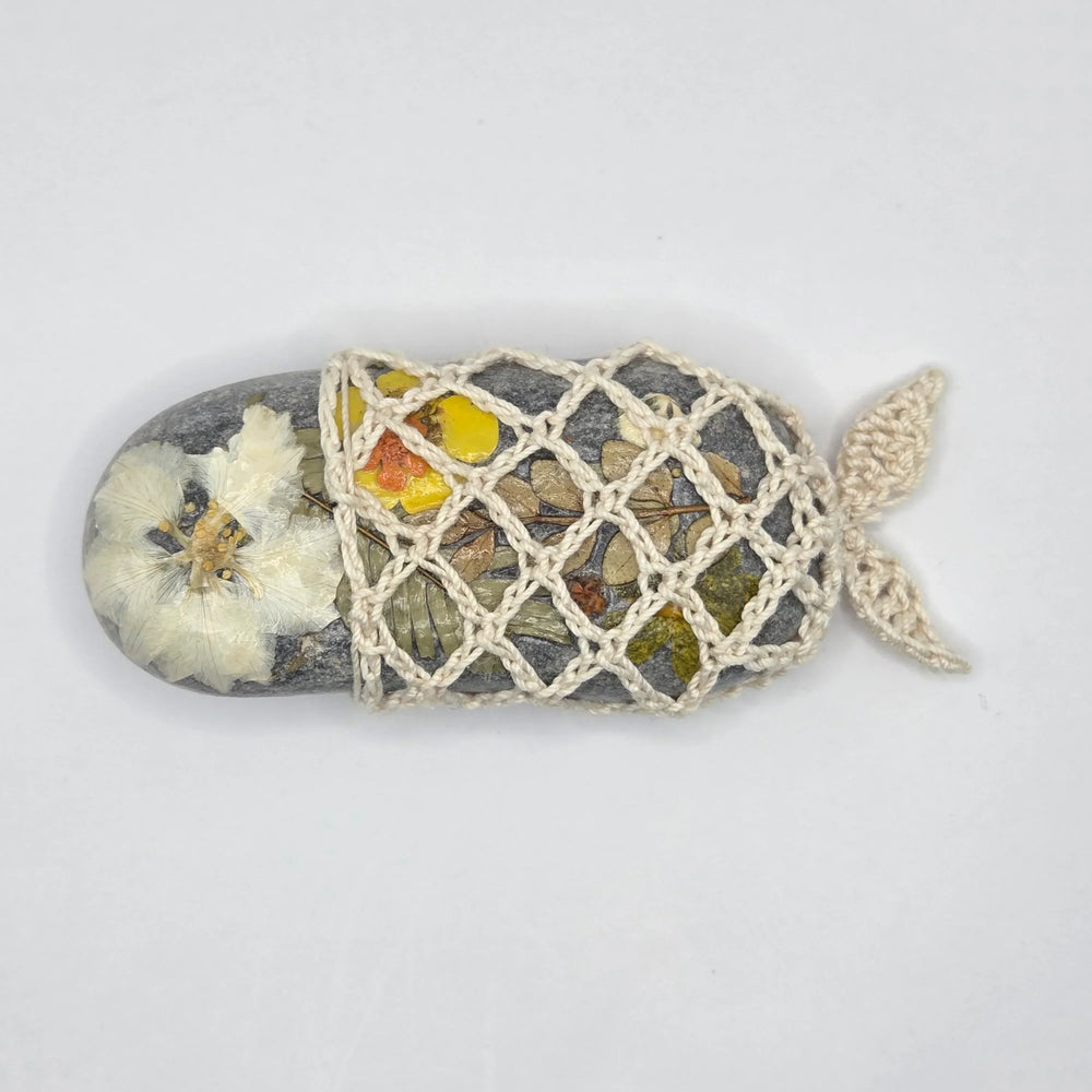 Handmade crochet-wrapped stone with pressed flowers, cozy nature-inspired decor