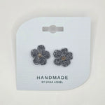 Handmade crochet flower earrings with gray yarn and pearl centers on white card
