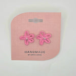 Handmade pink crochet flower earrings with silver beads on display card