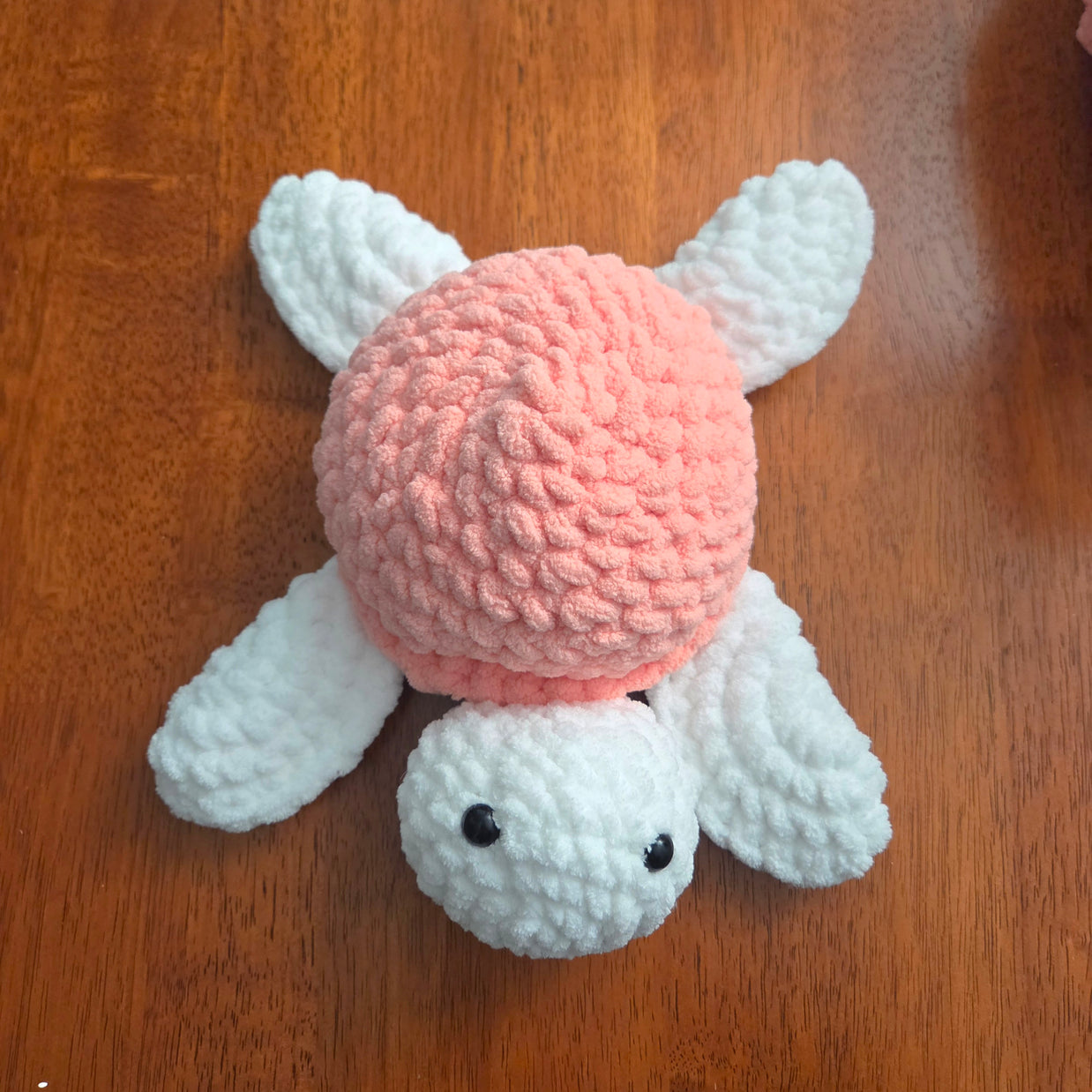 Handmade crochet bunny with pink body and white ears, perfect for cozy gifts