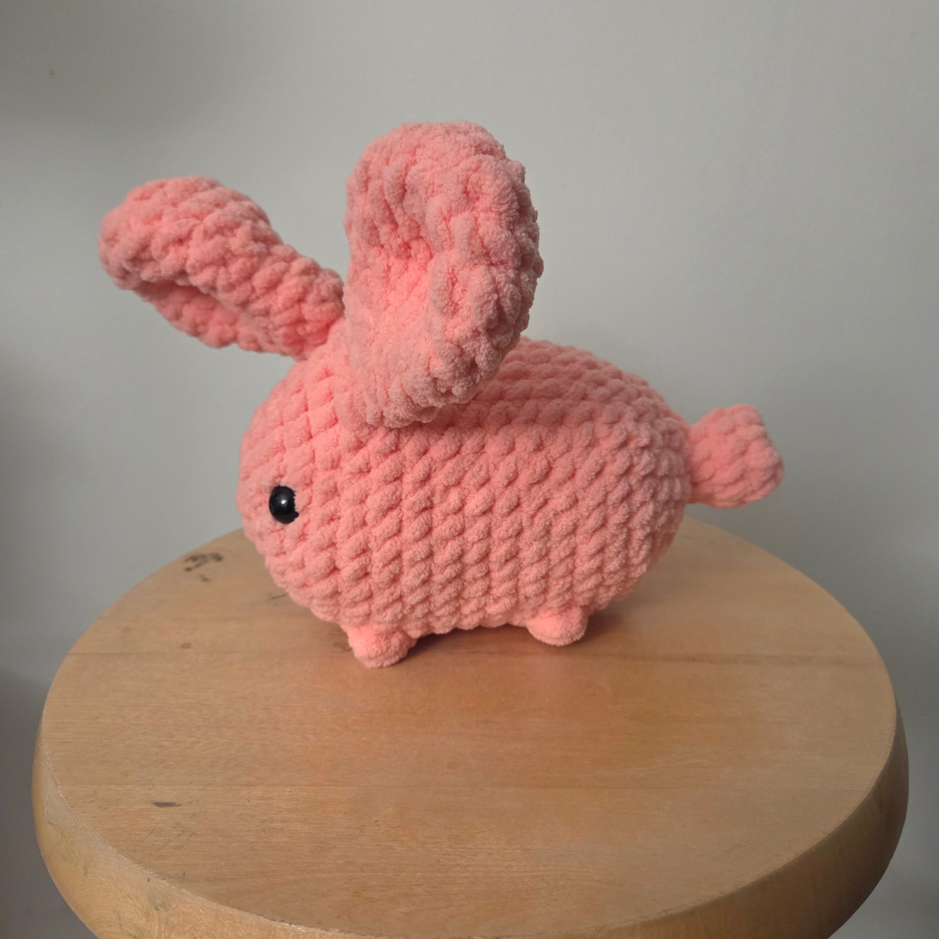Handmade pink crochet bunny with fluffy texture, perfect for cozy home decor or gifting.