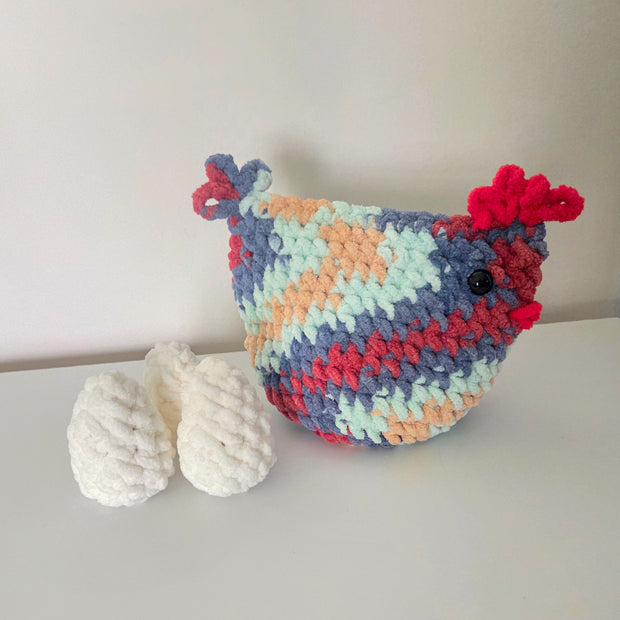 Colorful crocheted chicken with white eggs, handmade cozy decor