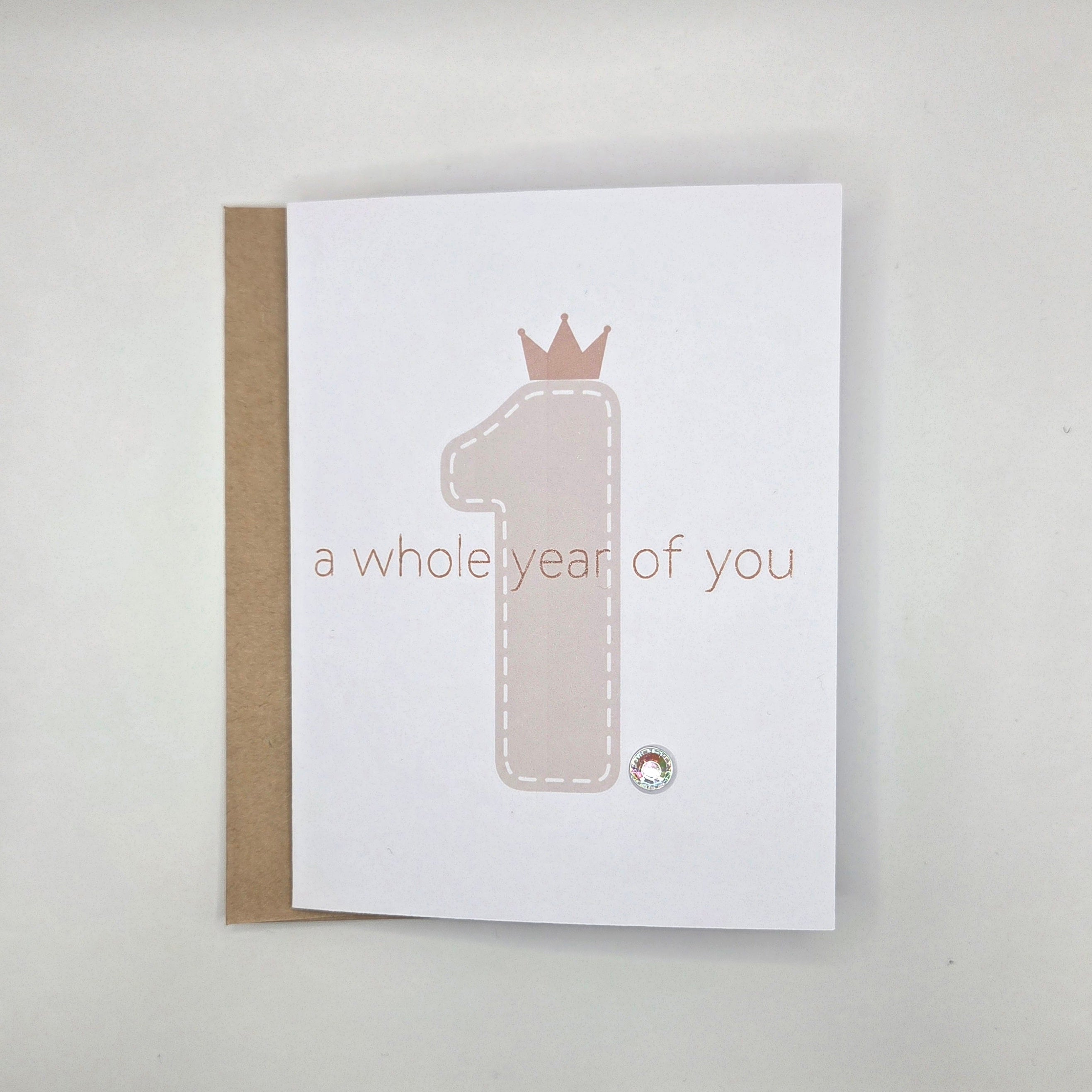 First birthday card with crown number one and 'a whole year of you' text