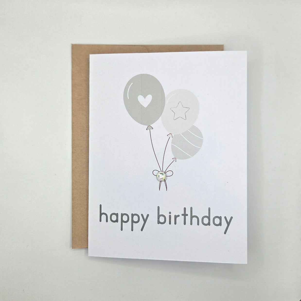Happy birthday card with gray balloons, heart, star, and gem accent