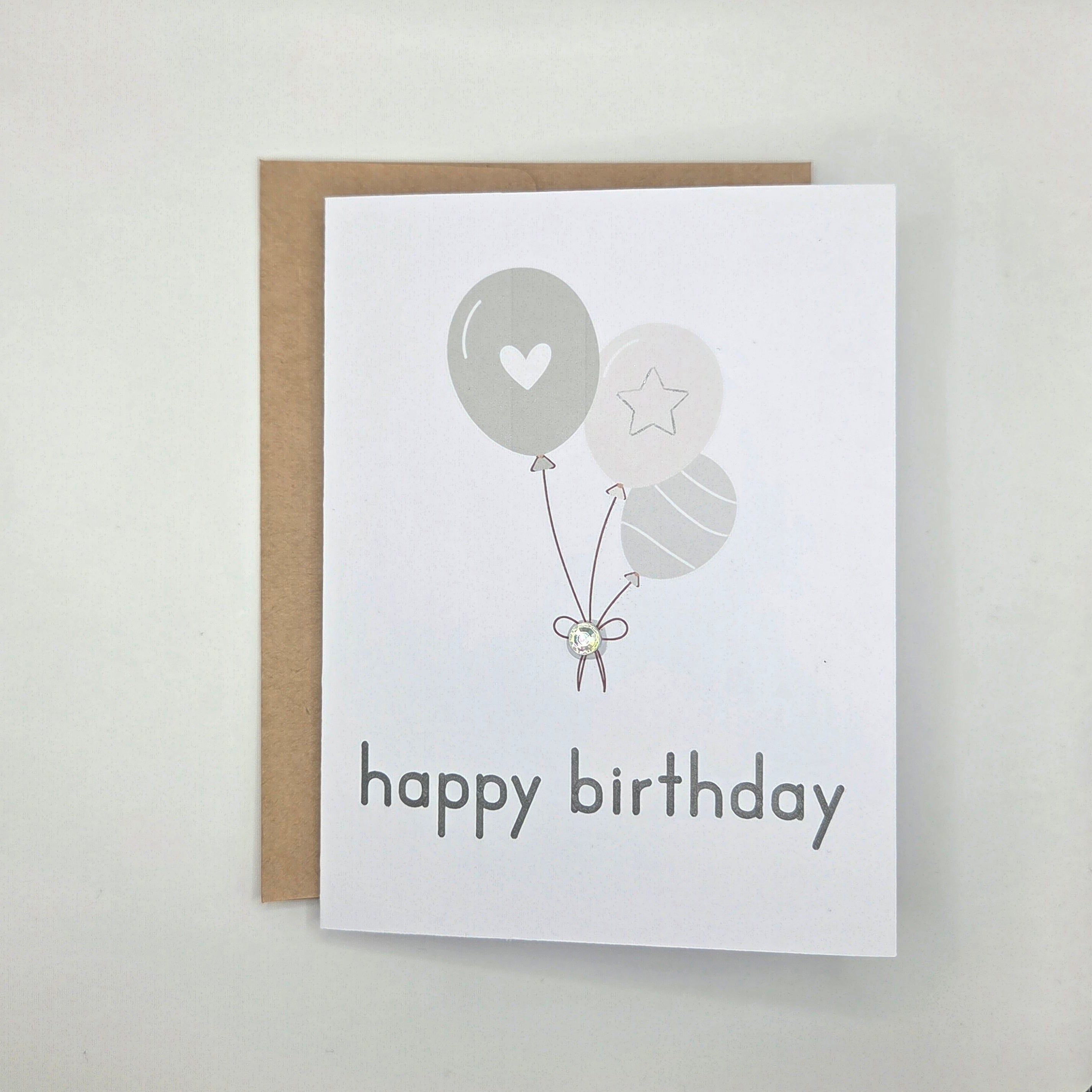 Happy birthday card with gray balloons, heart, star, and gem accent
