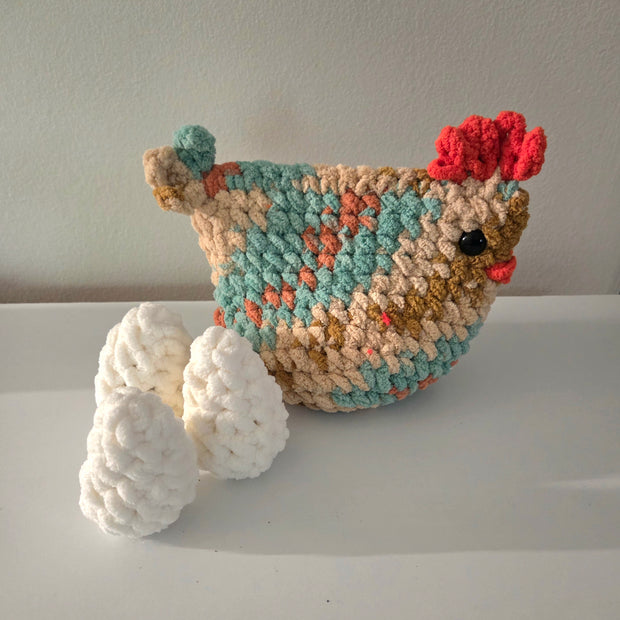 Handmade crochet chicken with colorful pattern and white eggs, cozy home decor