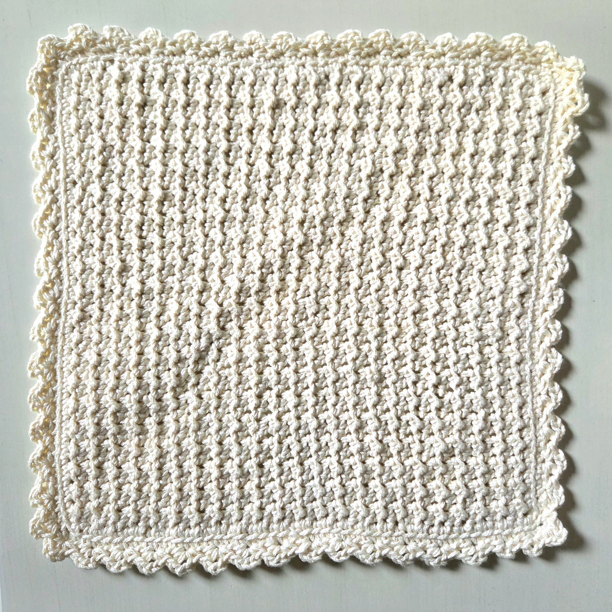 Handmade crochet dishcloth with scalloped edges, cozy and textured for kitchen use