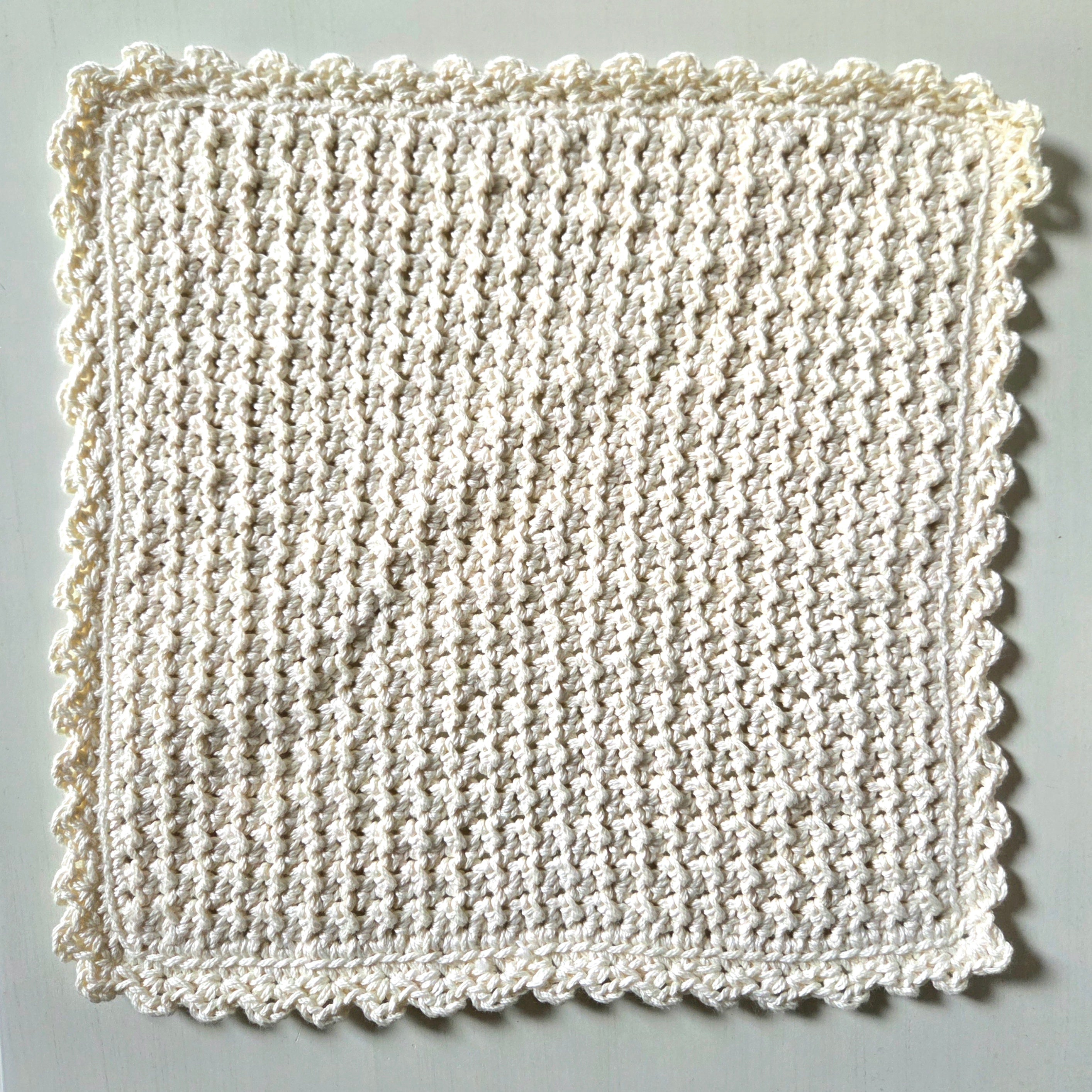 Handmade crochet dishcloth with scalloped edges, cozy and textured for kitchen use