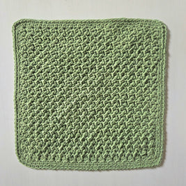 Handmade green crochet dishcloth with textured pattern for cozy kitchen use
