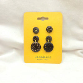 Handmade coconut shell button earrings on yellow card, natural texture, gold accents, artisan crafted