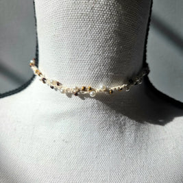 Delicate handmade pearl and gold bead choker necklace on white mannequin, cozy crochet gift