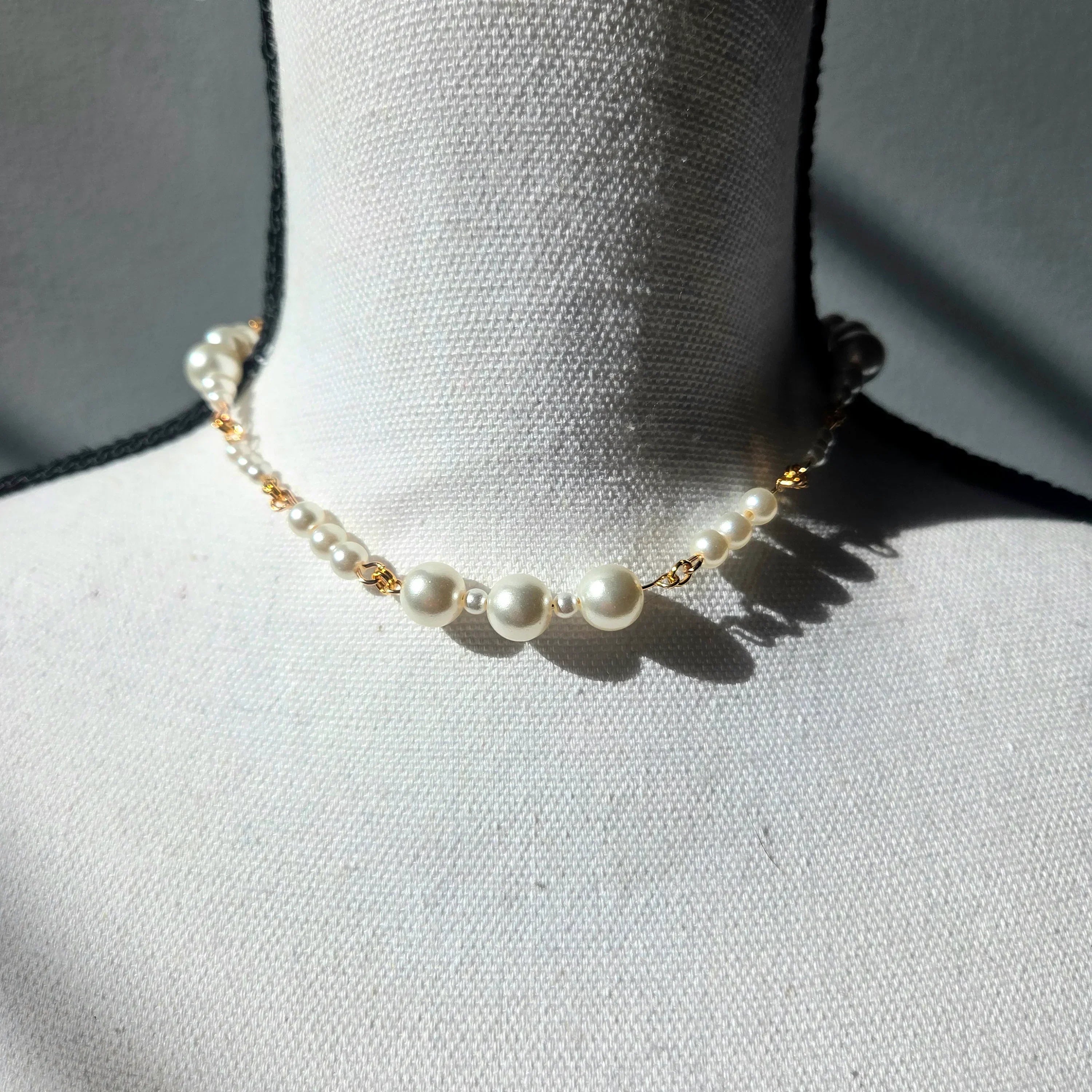 Elegant pearl necklace with gold chain on white mannequin, perfect for handmade gift ideas