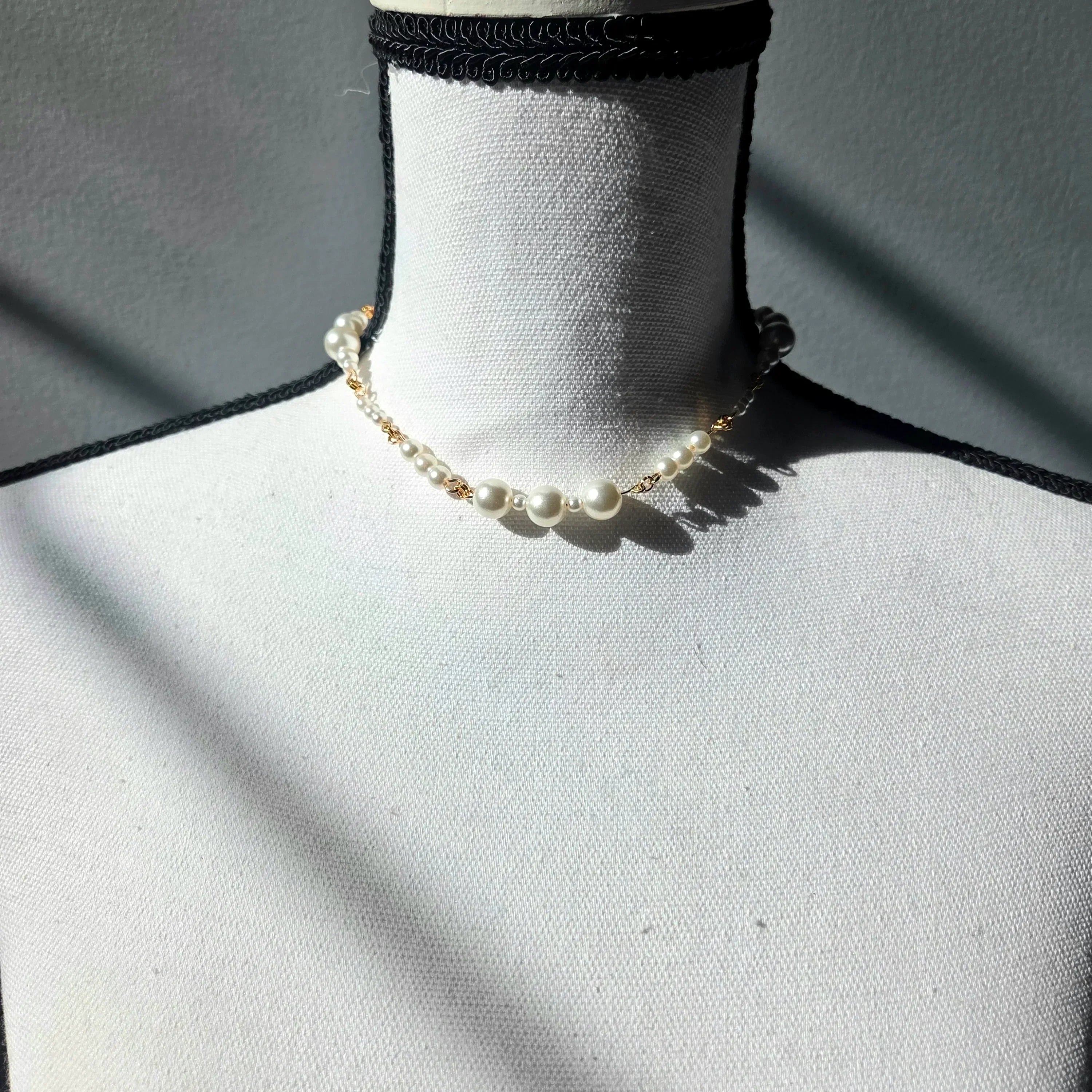 Delicate pearl necklace with gold chain on white mannequin, elegant handmade jewelry for everyday wear