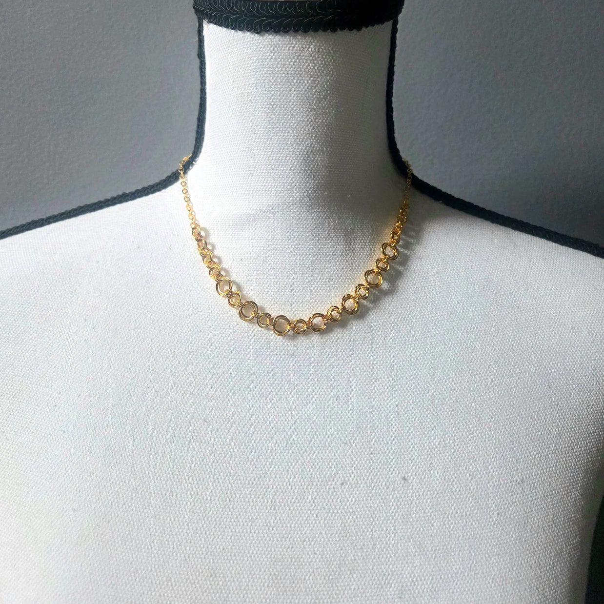 Gold circle link necklace on white mannequin, delicate chain jewelry for everyday wear