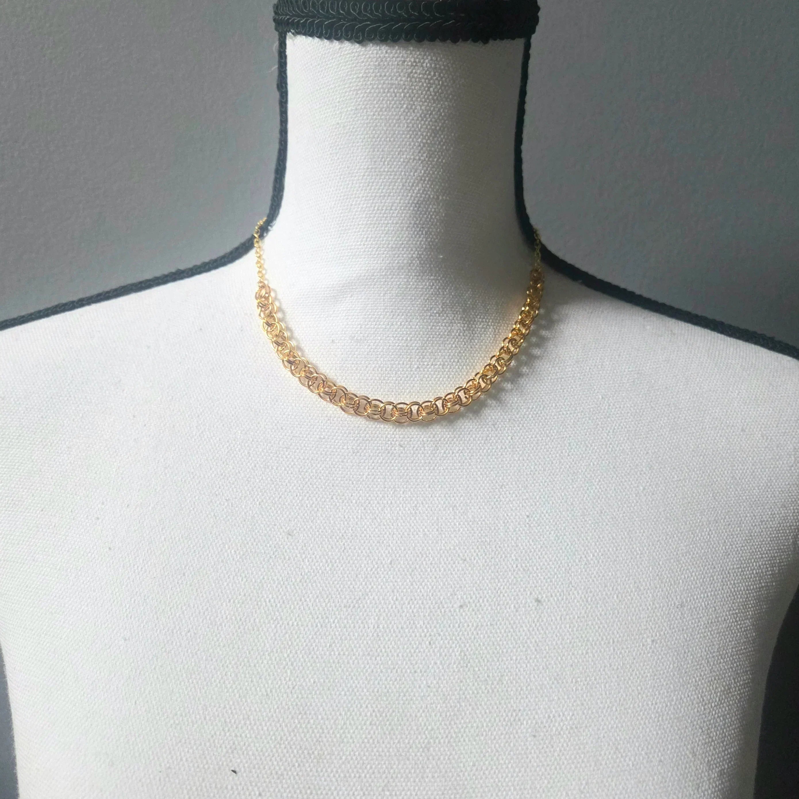 Gold chainmaille necklace on white mannequin, handmade jewelry for everyday wear