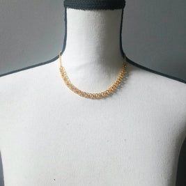 Gold chainmaille necklace on white mannequin, handmade jewelry for everyday wear